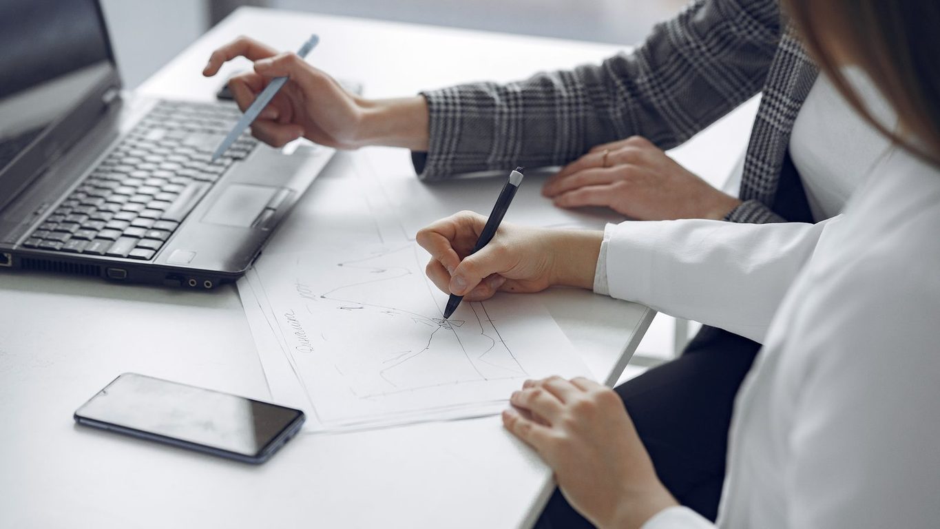Dos personas revisando juntas una grafica de resultados sobre el escritorio